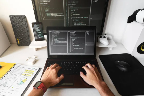 Крупним планом чоловічі руки на ноутбуці на сучасному робочому місці розробника для написання коду . — стокове фото