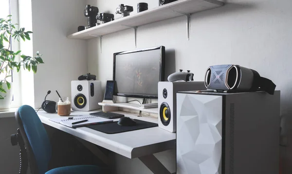 Bilgisayar monitörlü, ses hoparlörlü ve sütlü kahveli modern ofis işyeri