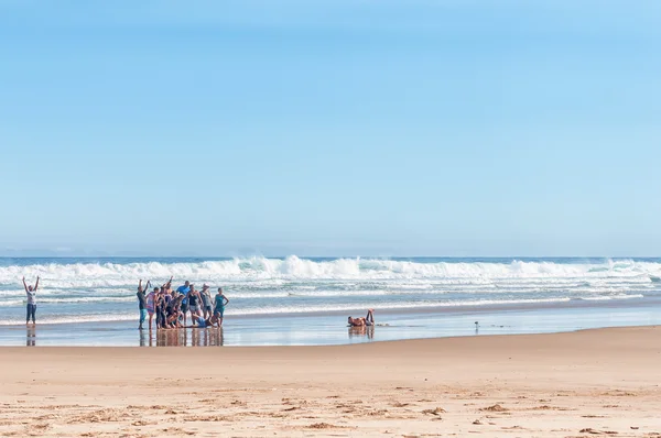 Visitors taking a group photo on a beach — Stock Photo, Image