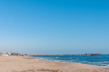 SWAKOPMUND, NAMIBIA - 18 Haziran 2012: Alman döneminden tarihi iskelenin Swakopmund 'da çekildiği bir plaj sahnesi
