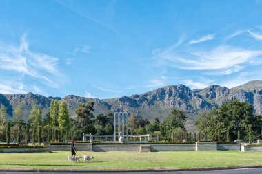 FRANSCHHOEK, Güney Afrika - 12 Nisan 2021: Batı Cape Eyaleti Franschhoek 'teki Fransız Protestan Anıtı. Köpekleri gezdiren biri görünür.