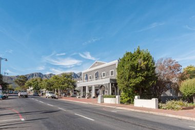 FRANSCHHOEK, Güney Afrika - 12 Nisan 2021: Batı Cape Eyaleti Franschhoek 'teki iş ve araçlarla dolu bir sokak sahnesi