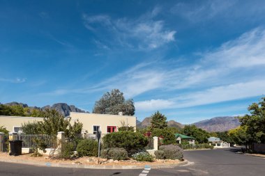 FRANSCHHOEK, Güney Afrika - 12 Nisan 2021: Batı Cape Eyaleti 'ndeki Franschhoek' te evleri olan bir sokak sahnesi. Bir çöp kutusu görünüyor.