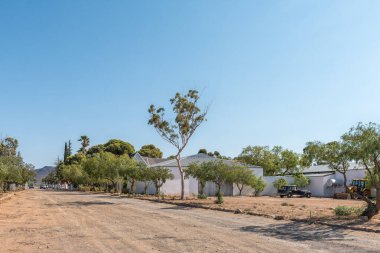 MATJIESFONTEIN, SOUTH AFRICA - 20 Nisan 2021: Batı Cape Eyaleti 'ndeki Matjiesfontein taşımacılık müzesi ile bir sokak sahnesi. Bir vitage araba ve bir ön yükleyici görünür.