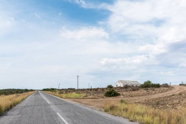 Doğu Burnu Bölgesi 'nde Willowmore ve Steytlerville arasındaki R329 yolunda manzara. Bir çiftlik binası görünür.