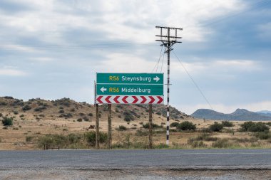 Doğu Cape Eyaleti Middelburg ve Steynsburg arasındaki R56 yolundaki Schoombee 'de yön işareti. Bir telefon hattı görünüyor.