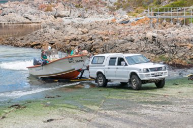 Crayfish boat being pulled onto trailer at Kleinmond harbor clipart