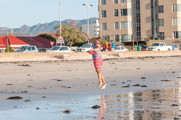 Persoon spelen op het strand in de ondergaande zon — Stockfoto