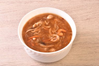 Beyaz kasede deniz tarağı çorbası ile çeşitli deniz ürünleri.