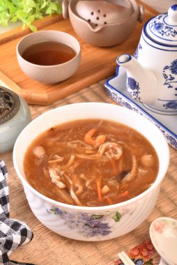 Beyaz kasede deniz tarağı çorbası ile çeşitli deniz ürünleri.