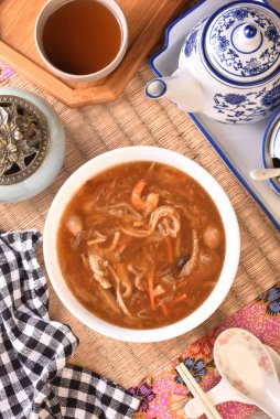 Beyaz kasede deniz tarağı çorbası ile çeşitli deniz ürünleri.