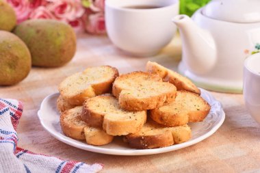 Beyaz tabakta pesto soslu yuvarlak rusklar.