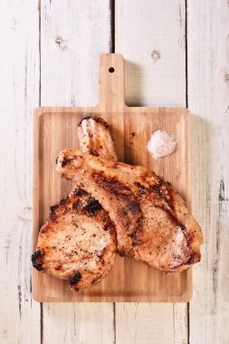 Tahtada kızartılmış iki domuz pirzolası.