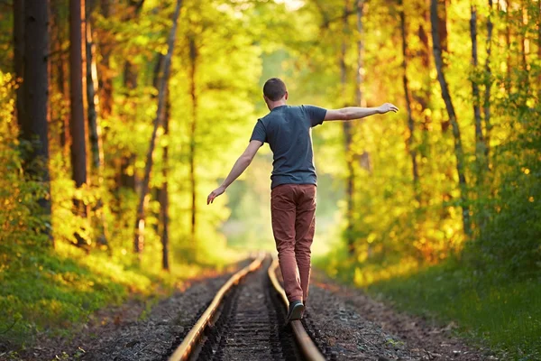 若い男が、鉄道の上を歩く — ストック写真