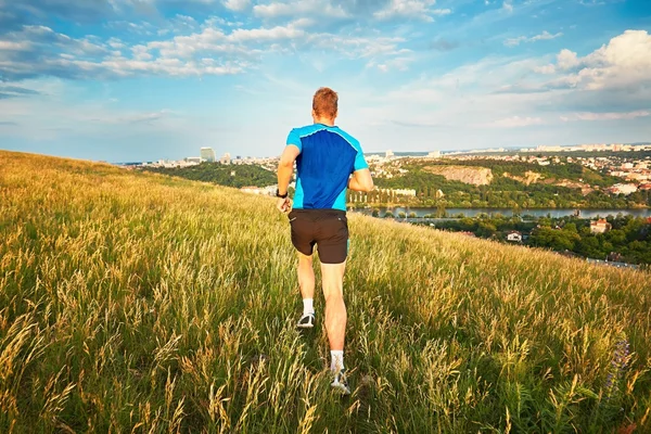 Atletisk runner på bjergsiden - Stock-foto