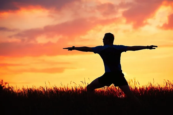 Człowiek jest Praktykowanie jogi podczas zachodu słońca — Zdjęcie stockowe