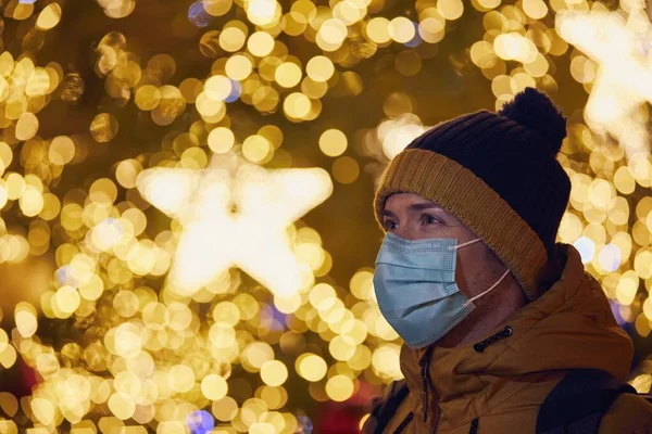 在布拉格 一个戴着面具的年轻人撞上了圣诞树 圣诞假期期间的大流行病和个人责任 — 图库照片