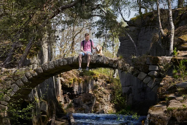 Fiatalember Kutyájával Öreg Kőhídon Gyönyörű Természetben Turista Labrador Pihen Erdő — Stock Fotó