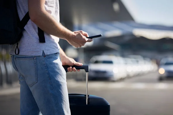Homem Segurando Smartphone Usando Aplicativo Móvel Contra Uma Fileira Carros — Fotografia de Stock