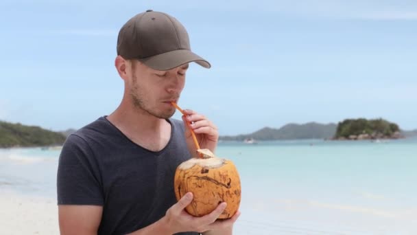 Homem Bebendo Coco Praia Areia Branca Contra Ilha Tropical Tempo — Vídeo de Stock