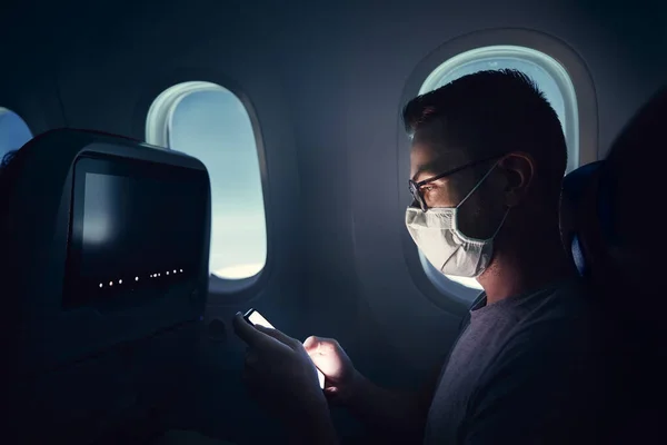 Muž Obličejovou Maskou Cestující Letadlem Cestující Telefonicky Během Letu — Stock fotografie
