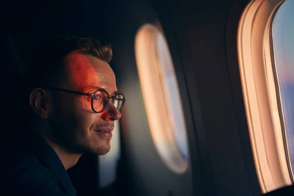 Young Man Eyeglasses Traveling Airplane Passenger Looking Window Flight Sunset — Stock Photo, Image