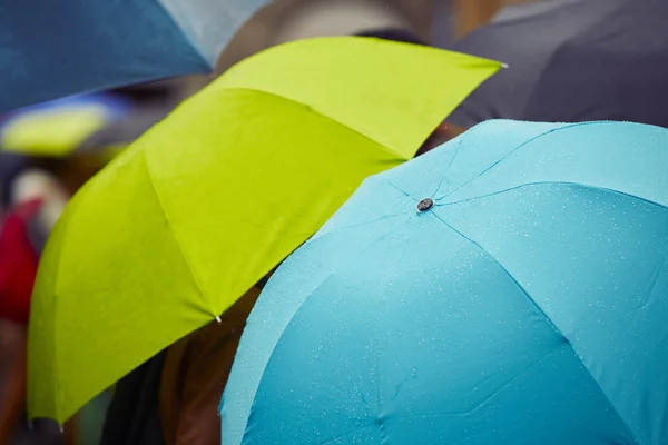 Personnes avec parasols sous la pluie — Photo