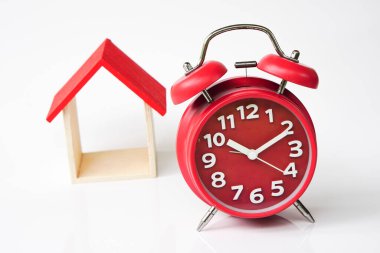 clock and miniature house on a white background, copy spae.