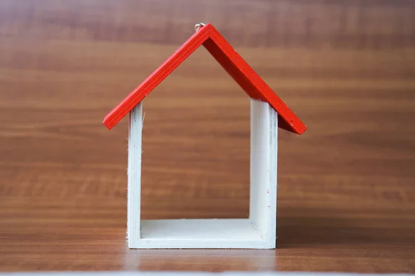 miniature house on wooden background, copy space.