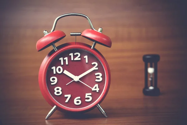 clock and mini sand clock on wooden background, copy spae.