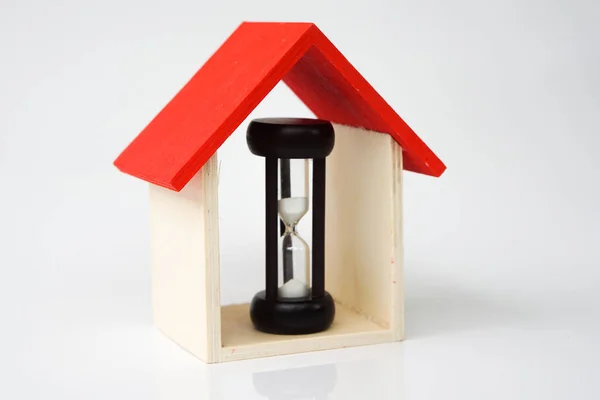  sand clock and miniature house on a white background, copy spae.