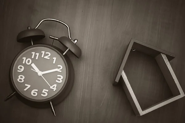 Tahta oyuncak ev ve ahşap arka planda saat. Boşluğu kopyala