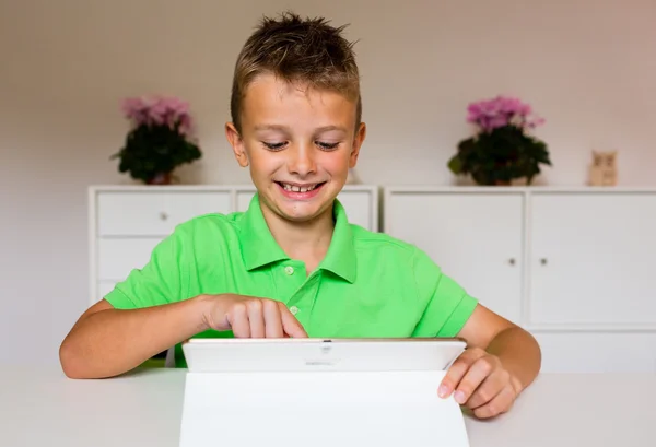 Niño feliz usando un comprimido blanco — Foto de Stock