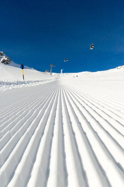 Piste de ski fraîchement damée par une journée ensoleillée — Photo