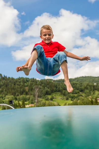 Young boy jumping on trampoline — Stock Photo, Image