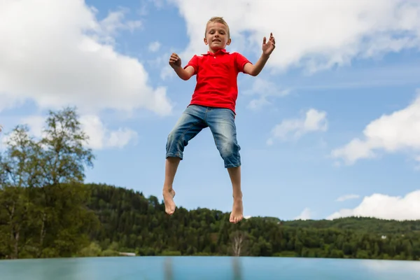 베개를 수신 거부에 점프 하는 어린 소년 — 스톡 사진