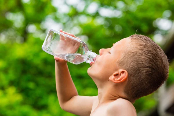 透明なプラスチック製のボトルからきれいな水道水を飲む子供 — ストック写真