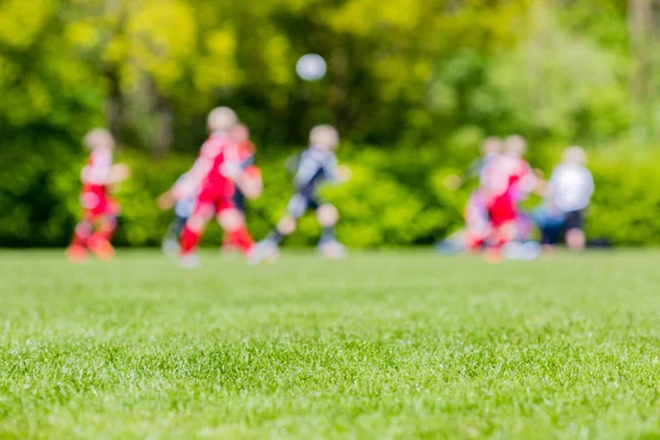 Niños borrosos jugando partido de fútbol juvenil — Foto de Stock