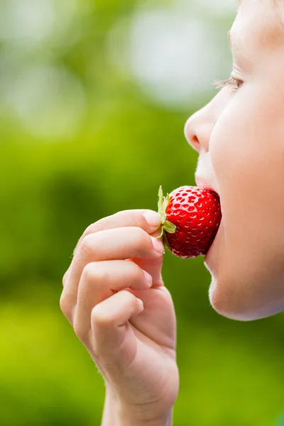 新鮮な赤いイチゴを食べる少年 — ストック写真