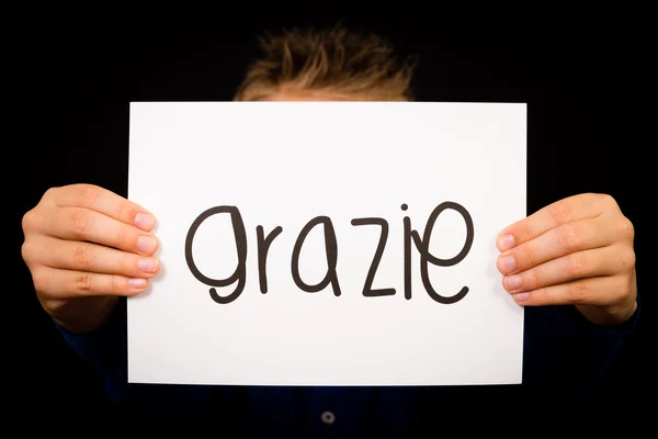 Dziecko trzyma znak z włoskiego słowa Grazie - dziękuję — Zdjęcie stockowe