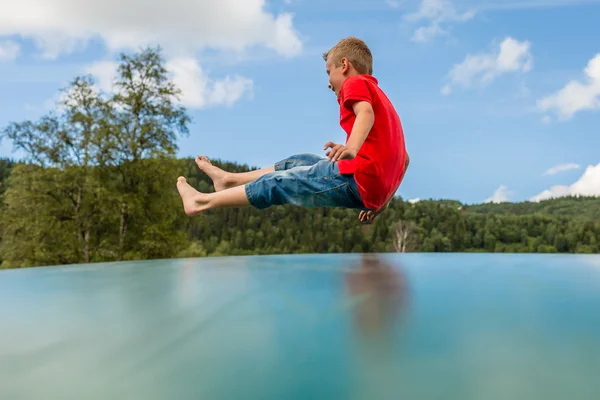 Young boy jumping on trampoline — Stock Photo, Image