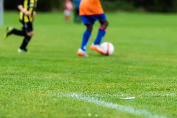 Blurred soccer players on green pitch — Stock Photo, Image