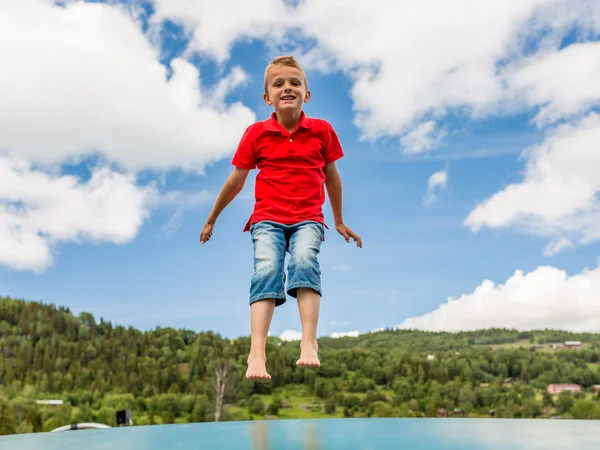 Jonge jongen springen op de trampoline — Stockfoto