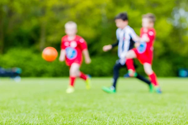 Blurred kids playing youth football match — Stock Photo, Image