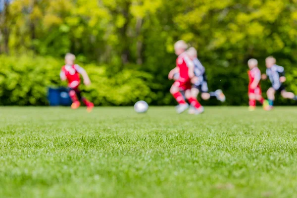 Suddig barn spelar ungdom fotboll matchar — Stockfoto