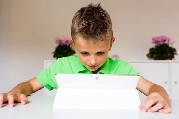 Niño sorprendido usando un comprimido blanco — Foto de Stock