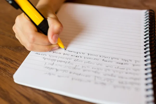 Niño escribiendo a mano en el bloc de notas — Foto de Stock