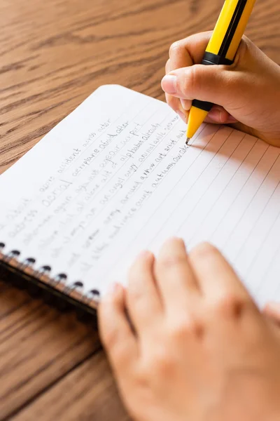 Barn skriva för hand på anteckningar — Stockfoto