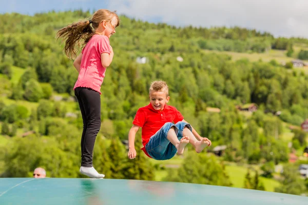 Dzieci podskakują w górę iw dół na trampolinie — Zdjęcie stockowe
