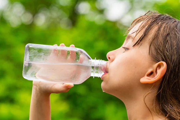 Barn dricka rent kranvatten från genomskinlig plastflaska — Stockfoto